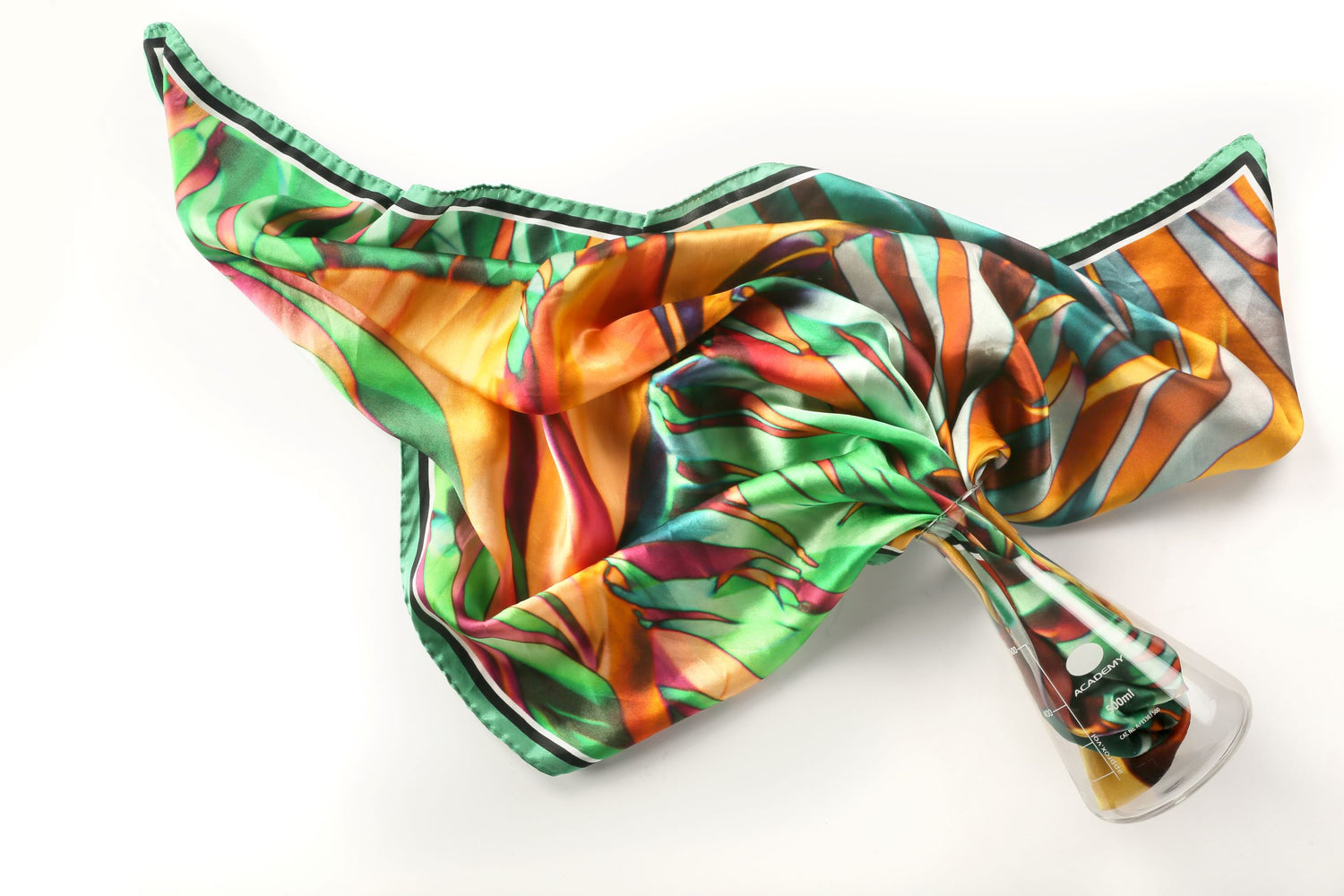 A By Biology leaf green luxury silk scarf displayed artistically emerging from a scientific flask